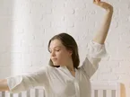 Kipihent nő nyújtózik az ágyban reggel jó alvás után